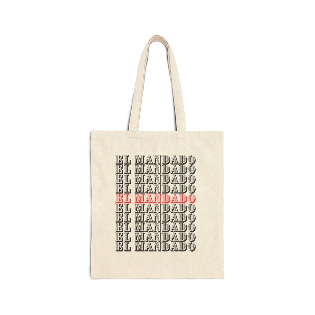 Beige tote bag with 'EL MANDADO' text in black and red on a white background