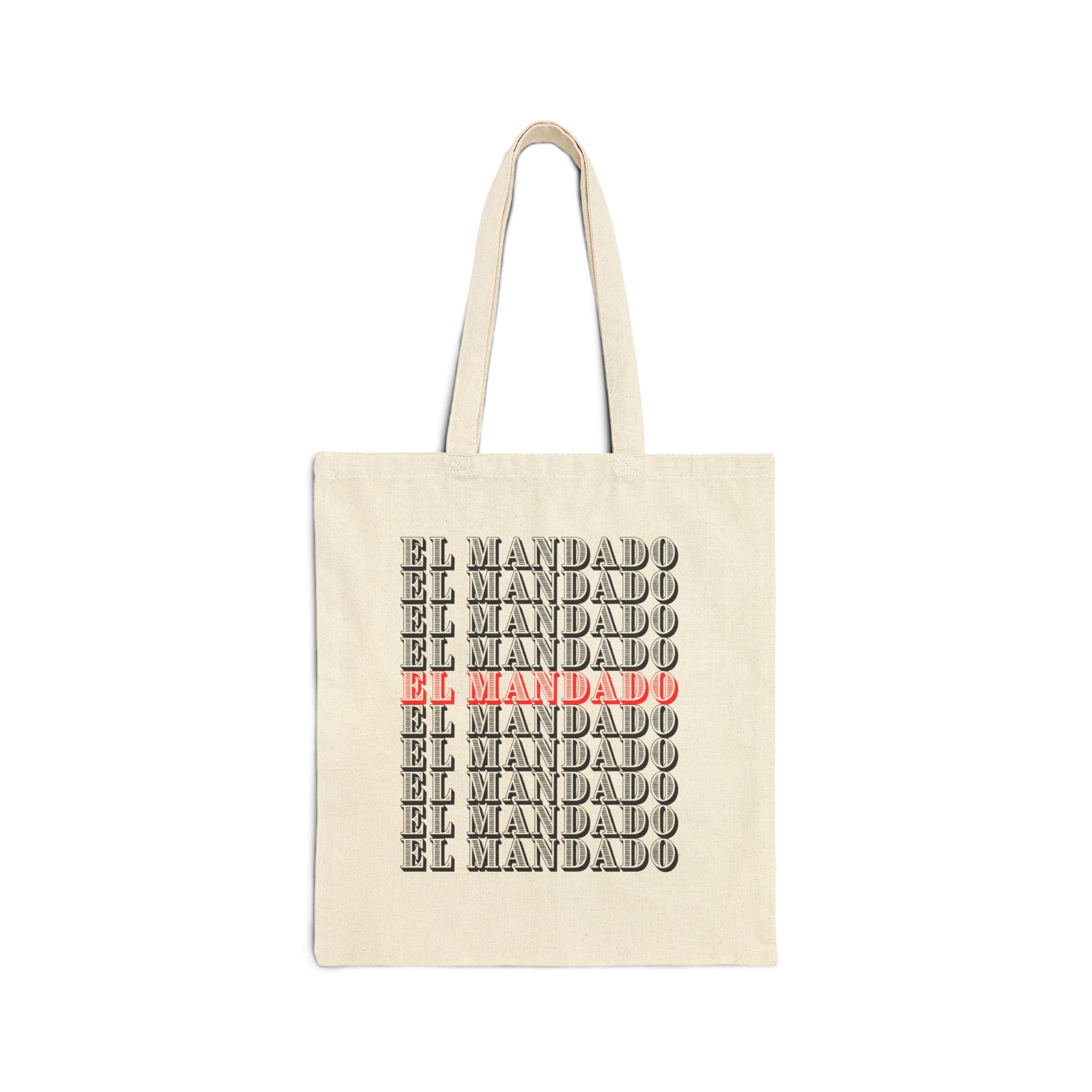 Beige tote bag with 'EL MANDADO' text in black and red on a white background