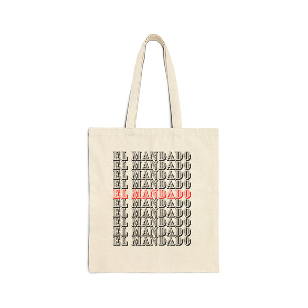 Beige tote bag with 'EL MANDADO' text in black and red on a white background