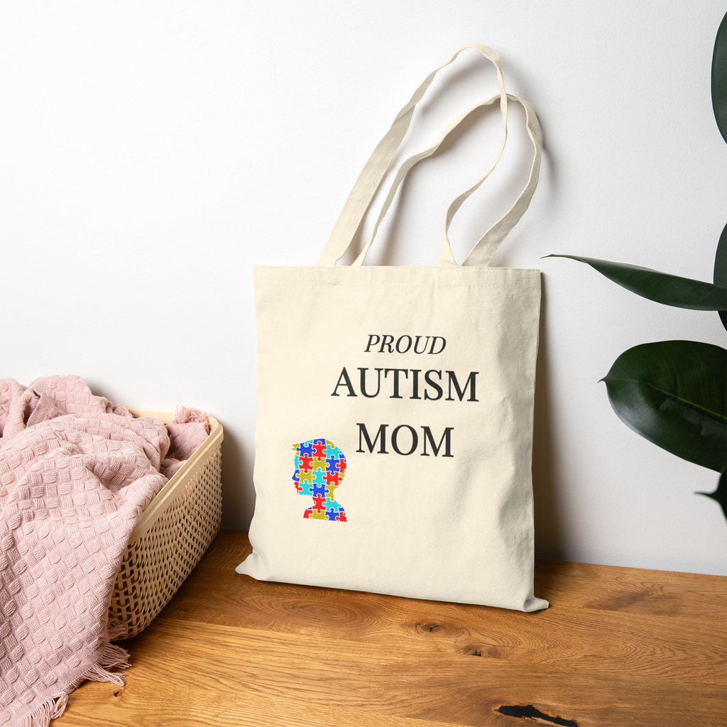 Woman carrying Autism Mom canvas tote bag with puzzle heart – meaningful autism awareness gift